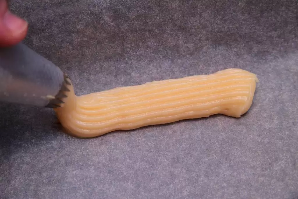 Making eclairs. Cakes Eclair. Series. Transfer on a baking sheet. |